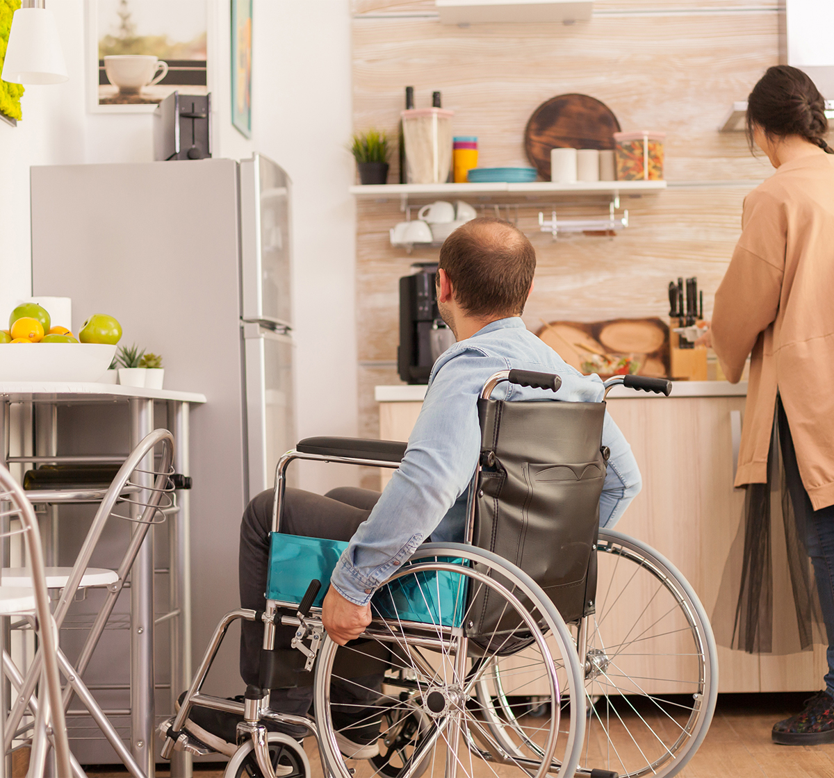 psychologist-08 A home care worker assists a wheelchair bound man in his kitchen